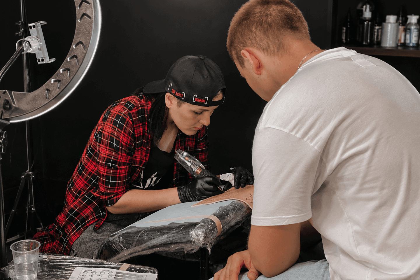 Tattoo student practising on synthetic skin with instructor