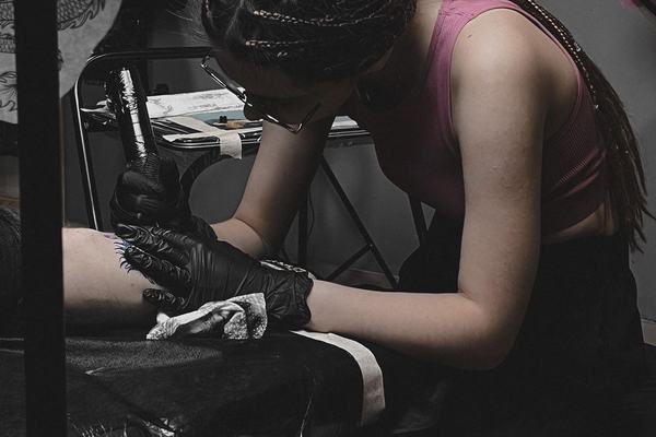 Tattoo student working with a tattoo machine