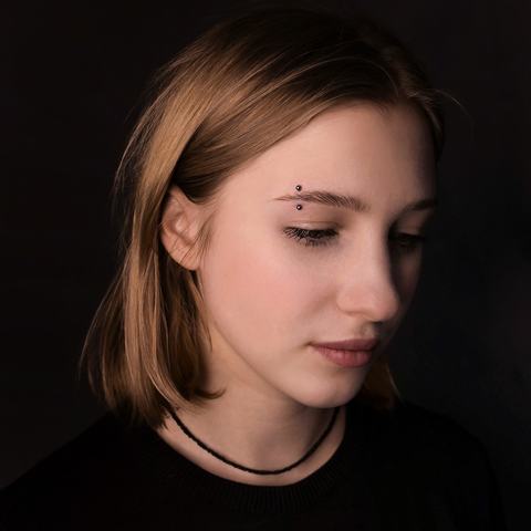 Eyebrow piercing with a clean, minimal look that follows the natural brow line. Precise placement and delicate jewellery create a subtle accent that feels sharp, stylish and easy to wear.