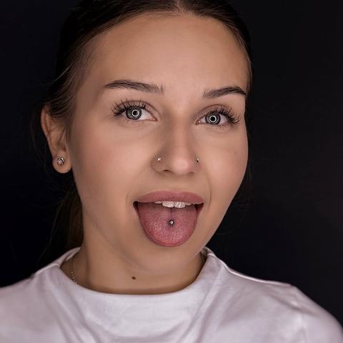 Tongue piercing with a clean central placement, paired with subtle nostril accents for a playful but balanced look. The procedure was performed under sterile conditions, with precise jewellery installation and clear healing advice.