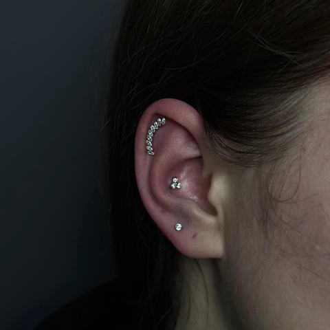 Curated ear piercing with delicate lobe and cartilage jewellery for a layered, elegant look. Each piece was placed to follow the natural shape of the ear, creating a neat and balanced composition.